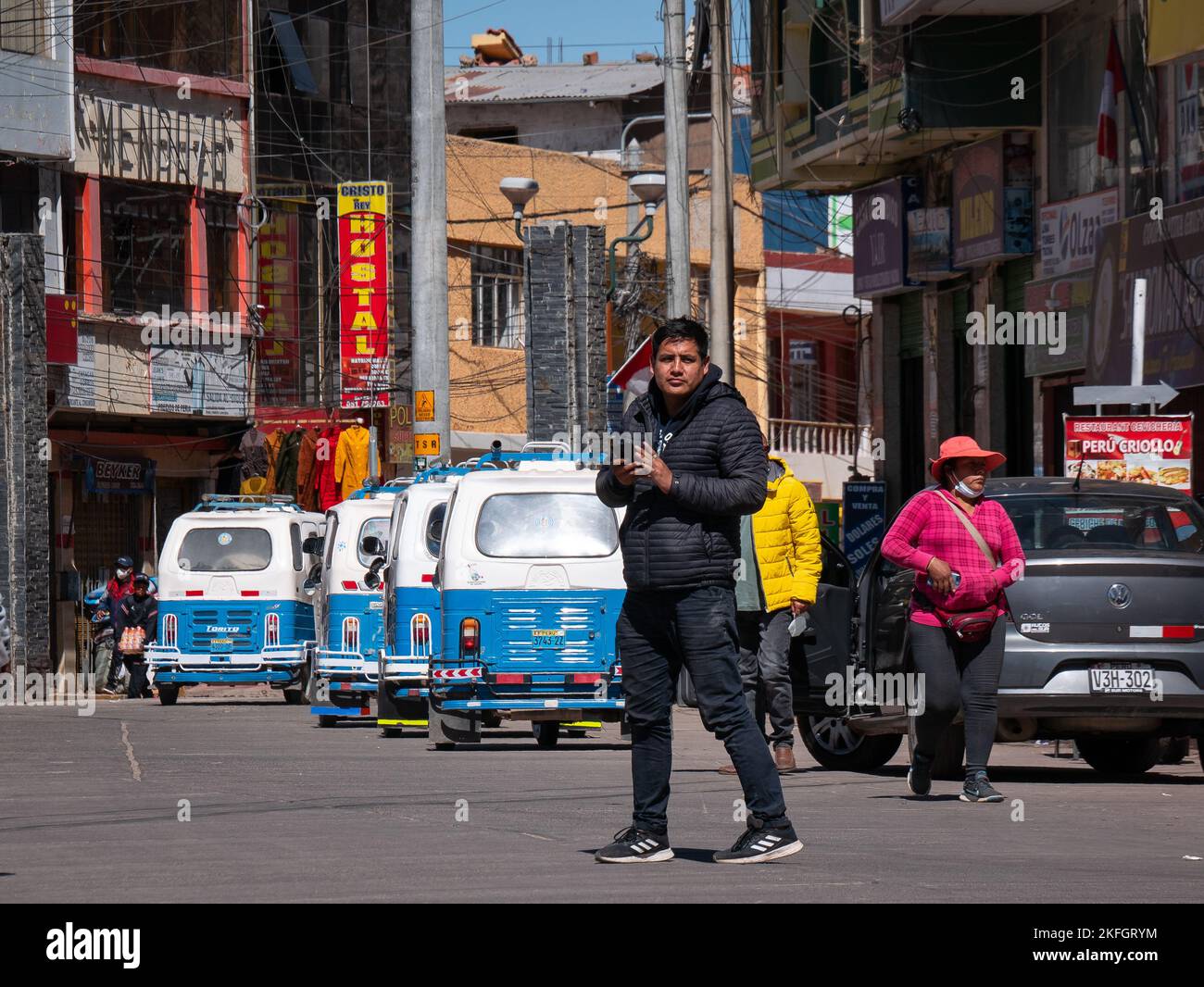 Desaguadero, Pérou - 28 juillet 2022: L'homme péruvien traverse la rue en observant attentivement un Autorickshaw s'approchant de lui Banque D'Images