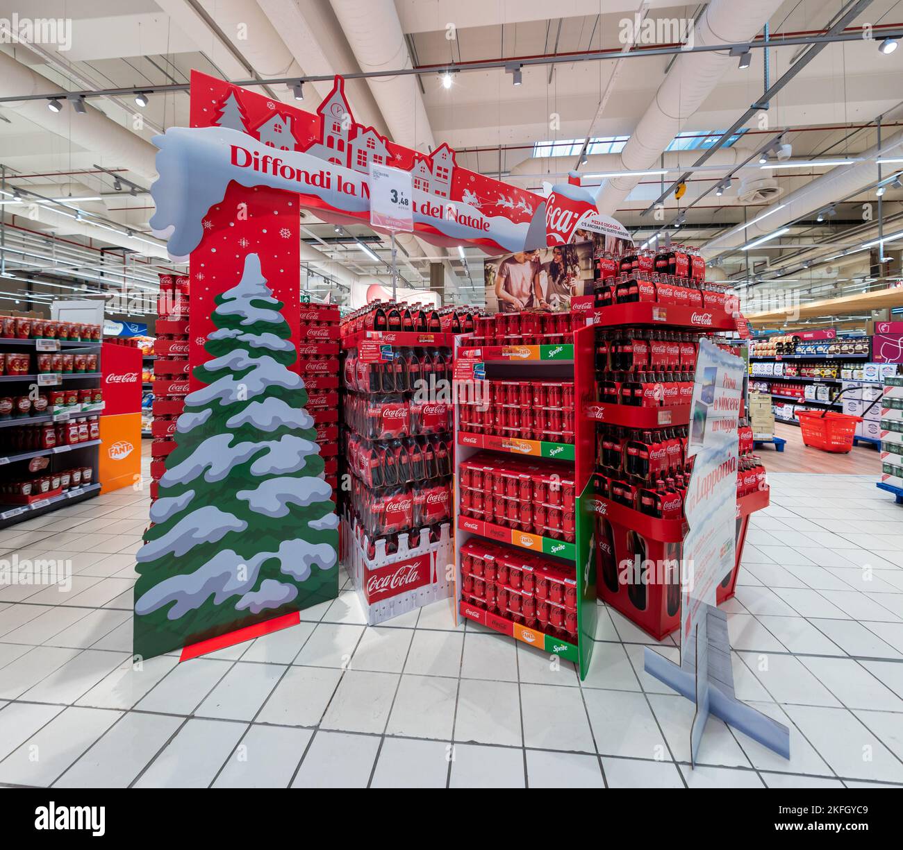 Cuneo, Italie - 18 novembre 2022: Présentoirs avec décorations de Noël pour vendre des emballages de bouteilles et de canettes de Coca-Cola avant Noël en italien Banque D'Images