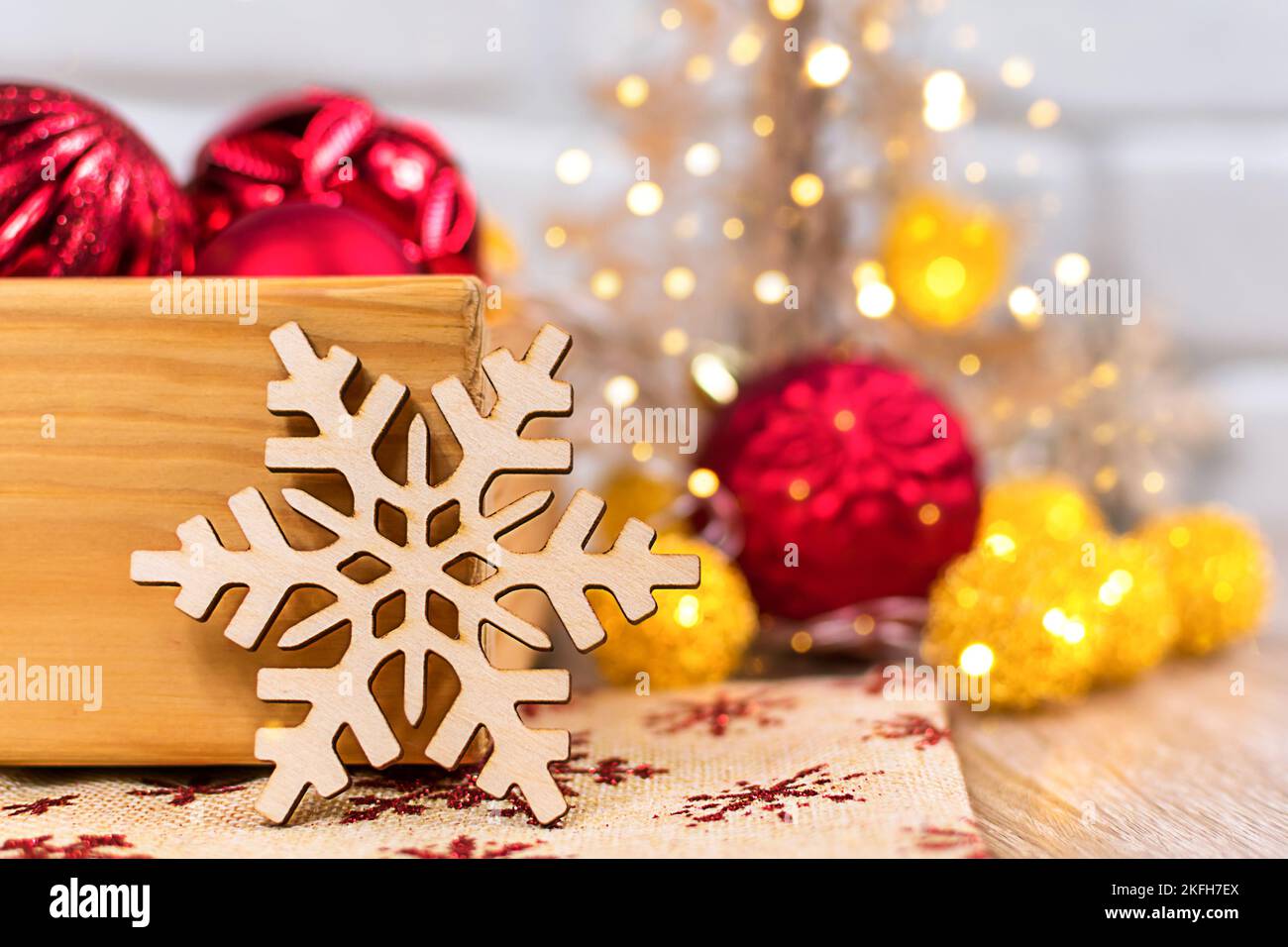 Flocon de neige sculpté dans le bois sur un fond flou. Carte du nouvel an. Banque D'Images