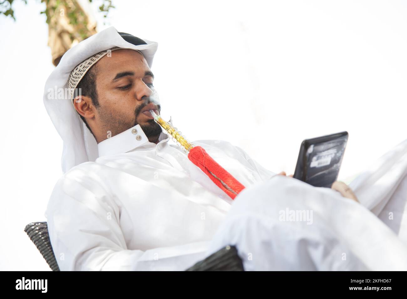 Doha, Qatar - 05 mars 2022 : les gens locaux fument la chicha dans le vieux marché. Banque D'Images Doha, Qatar - 05 mars 2022 : les gens locaux fument la chicha dans le vieux marché. Banque D'Images