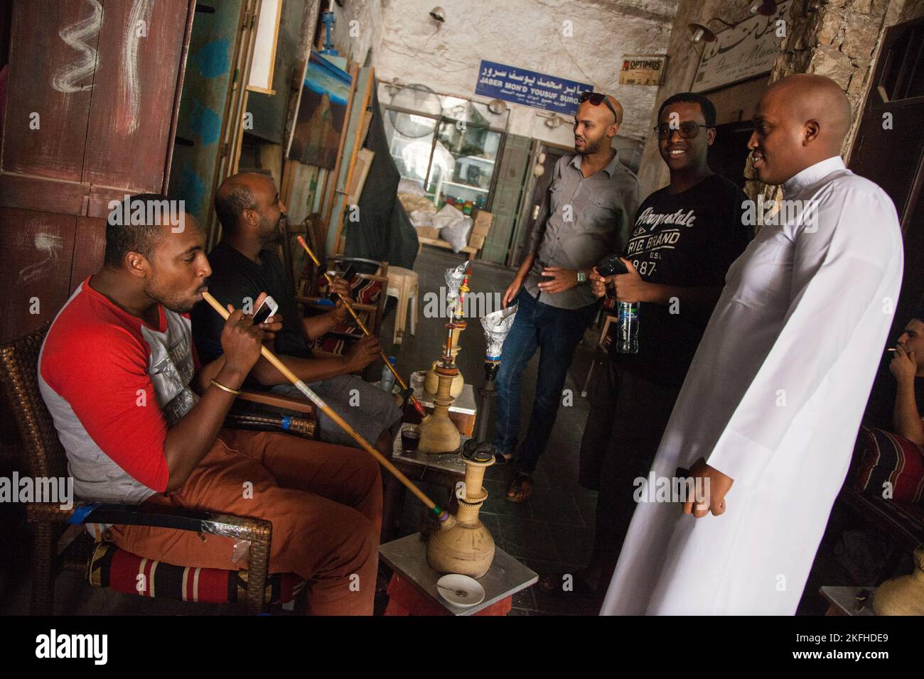 Doha, Qatar - 05 mars 2022 : les gens locaux fument la chicha dans le vieux marché. Banque D'Images Doha, Qatar - 05 mars 2022 : les gens locaux fument la chicha dans le vieux marché. Banque D'Images