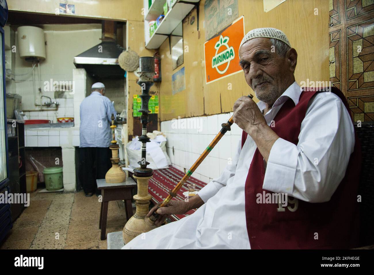 Doha, Qatar - 05 mars 2022 : les gens locaux fument la chicha dans le vieux marché. Banque D'Images Doha, Qatar - 05 mars 2022 : les gens locaux fument la chicha dans le vieux marché. Banque D'Images