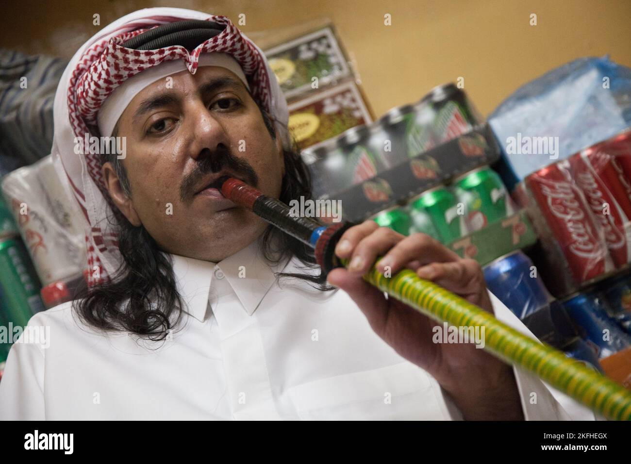 Doha, Qatar - 05 mars 2022 : les gens locaux fument la chicha dans le vieux marché. Banque D'Images Doha, Qatar - 05 mars 2022 : les gens locaux fument la chicha dans le vieux marché. Banque D'Images