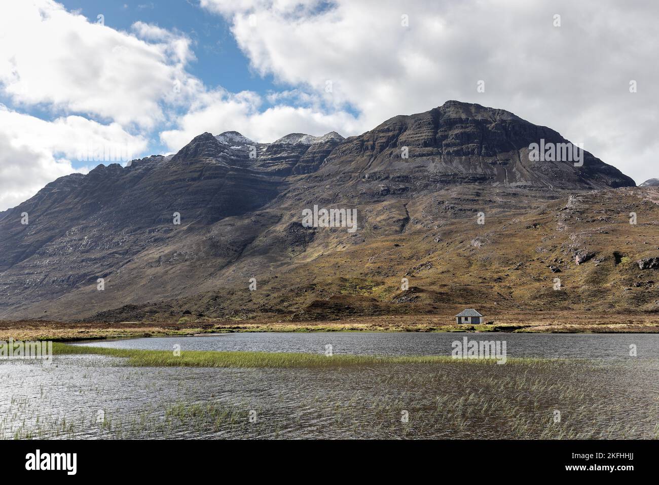 La montagne de Liathach s'enveloppait dans le nuage tandis que la douche à neige sautait à travers ses flancs, vue à travers Lochan an Lasgair, Torridon, Écosse, Royaume-Uni Banque D'Images