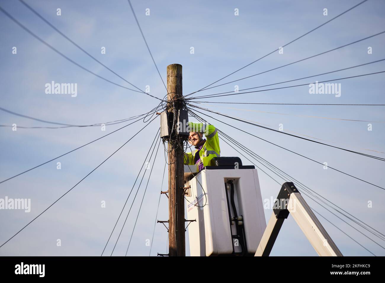 BT openreach ingénieur travaillant sur les fils téléphoniques d'un préparateur de cerisier Banque D'Images