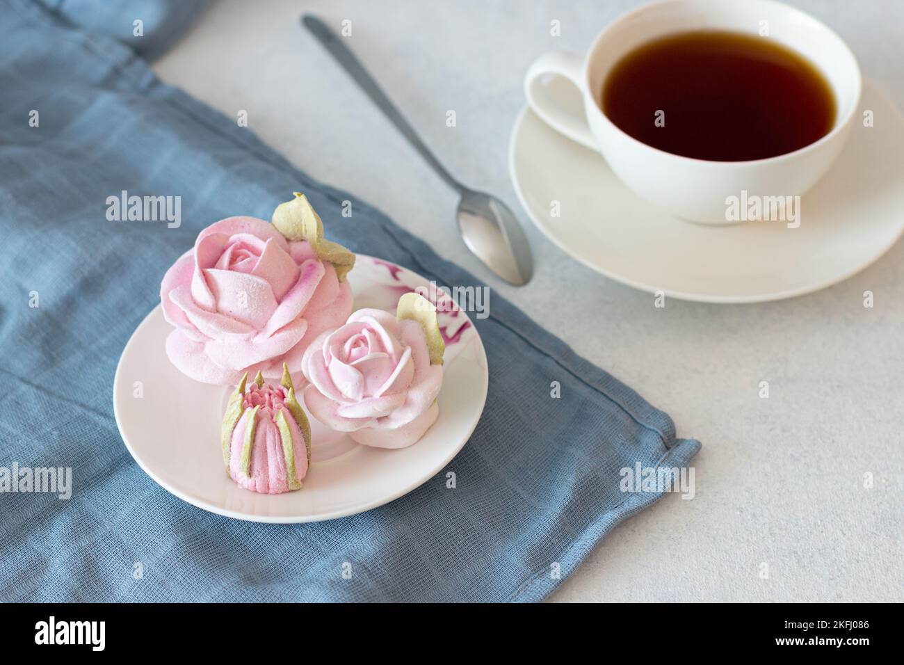 ensemble de thé dans une composition avec des fleurs de guimauve. Tasse à café sur soucoupe. Sur fond gris clair. Soirée thé revigorante le matin Banque D'Images