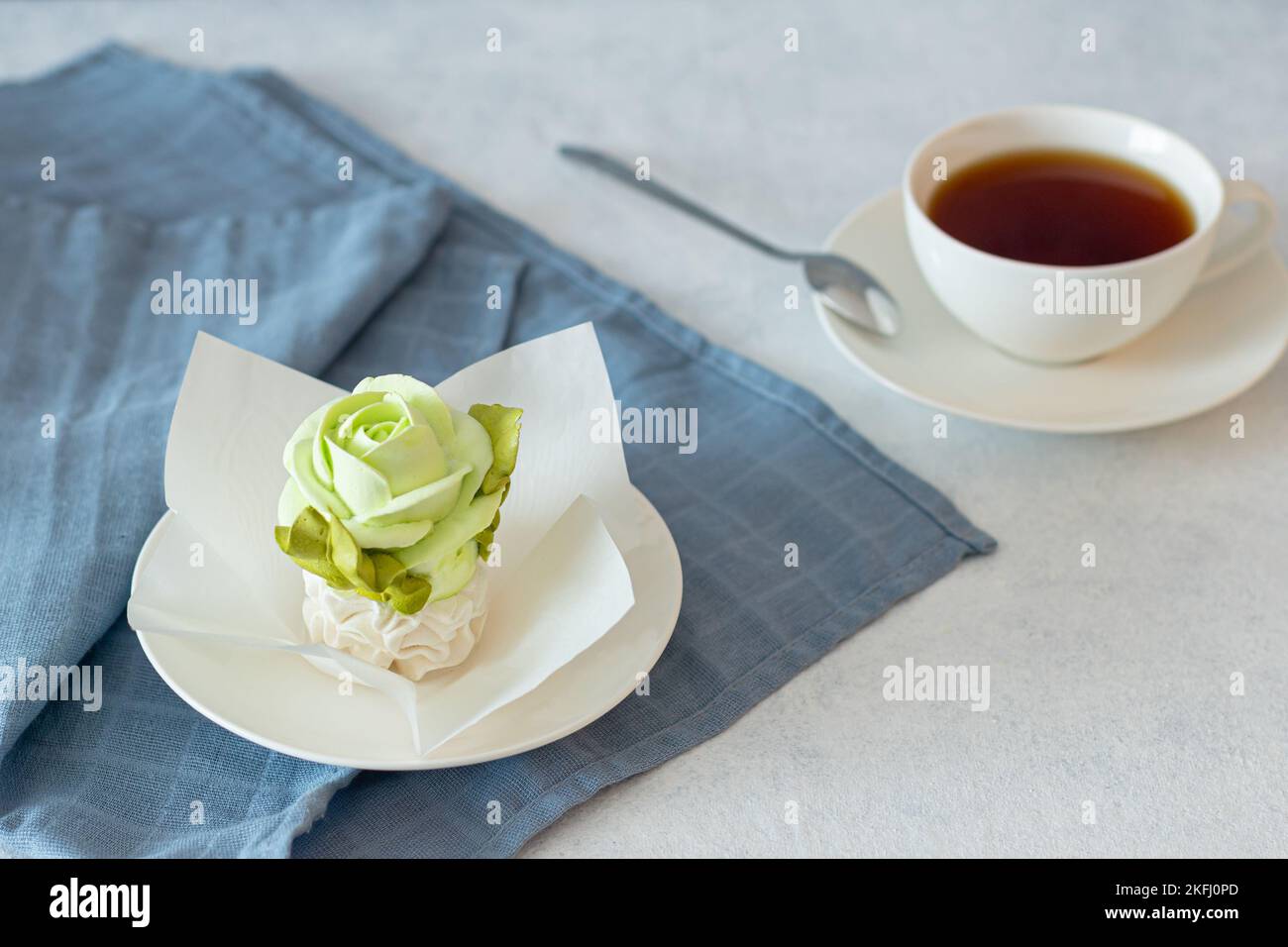 ensemble de thé dans une composition avec des fleurs de guimauve. Tasse à café sur soucoupe. Sur fond gris clair. Soirée thé revigorante le matin Banque D'Images