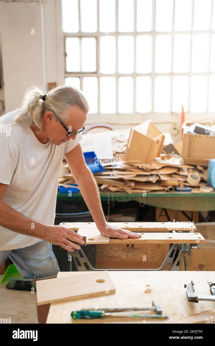 Professionnel homme âgé menuisier artiste travaillant sur le bois en utilisant des outils de menuiserie dans l'atelier Banque D'Images