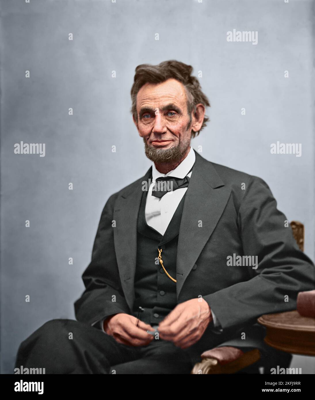 Portrait du président Abraham Lincoln, assis et tenant ses lunettes et un crayon. 1865 photo par Alexander Gardner. Photo colorée à la main et restaurée par des professionnels Banque D'Images