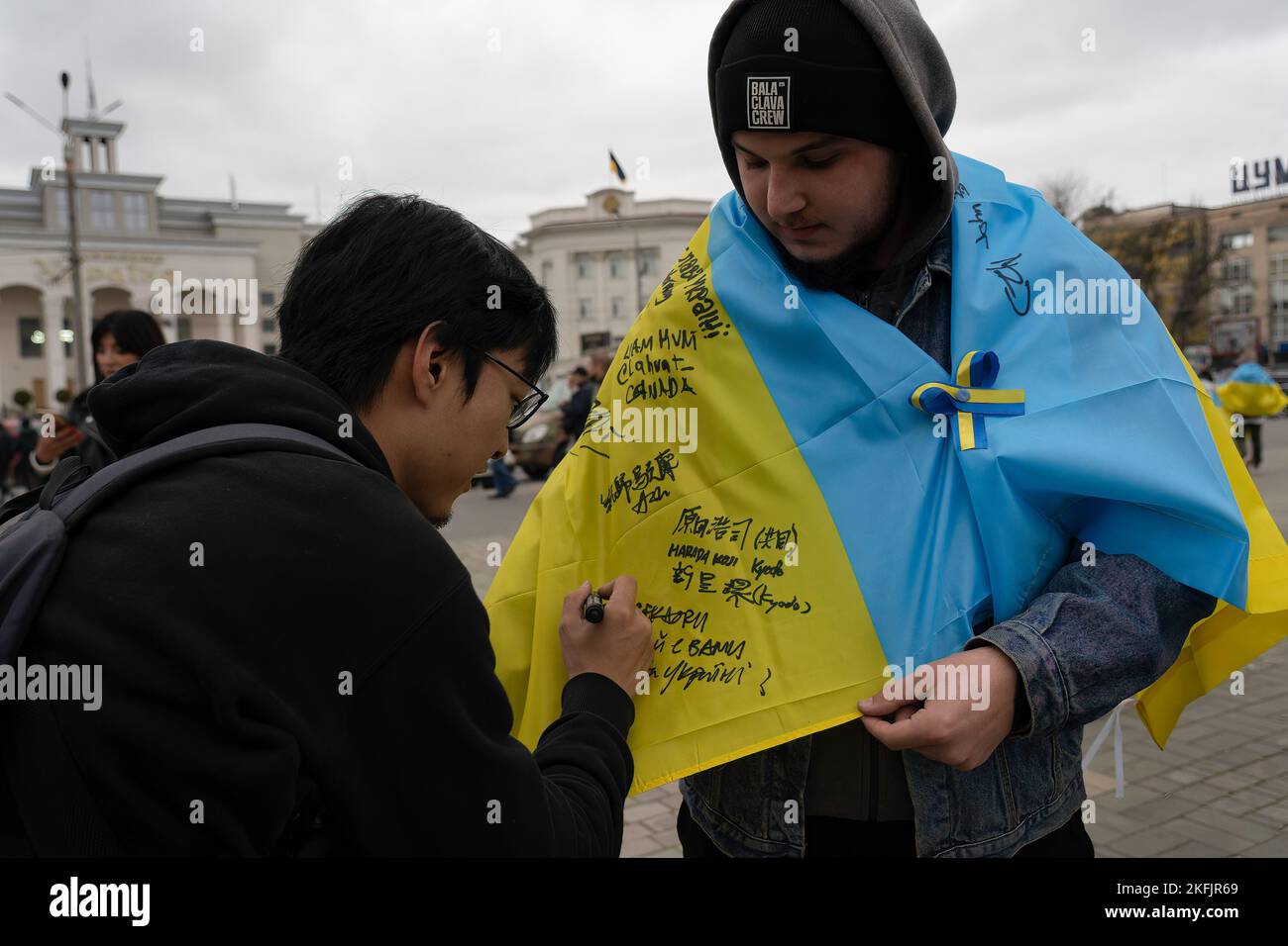 Kherson, Ukraine. 16th novembre 2022. Un résident de Kherson demande à un journaliste étranger de signer son drapeau. Les habitants de Kherson sont encore très heureux de la libération de la ville, mettant fin à plus de 8 mois d'occupation. Cependant, la capitale régionale du sud n'a toujours pas d'électricité, d'eau et un minimum de signal et d'approvisionnement alimentaire. Crédit : SOPA Images Limited/Alamy Live News Banque D'Images