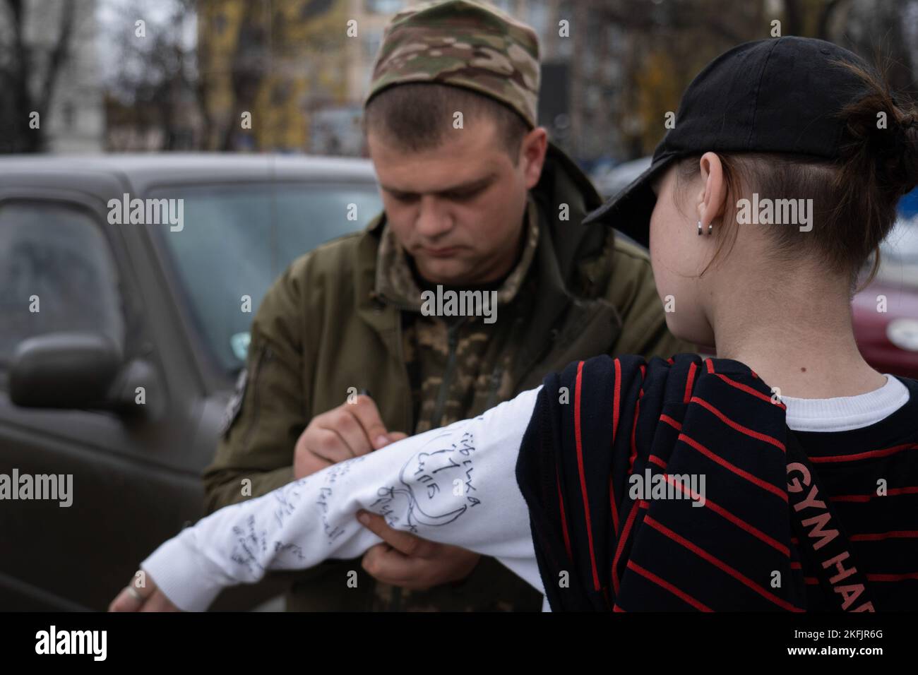 Kherson, Ukraine. 16th novembre 2022. On voit un soldat signer la manche d'un résident de Kherson. Les habitants de Kherson sont encore très heureux de la libération de la ville, mettant fin à plus de 8 mois d'occupation. Cependant, la capitale régionale du sud n'a toujours pas d'électricité, d'eau et un minimum de signal et d'approvisionnement alimentaire. Crédit : SOPA Images Limited/Alamy Live News Banque D'Images