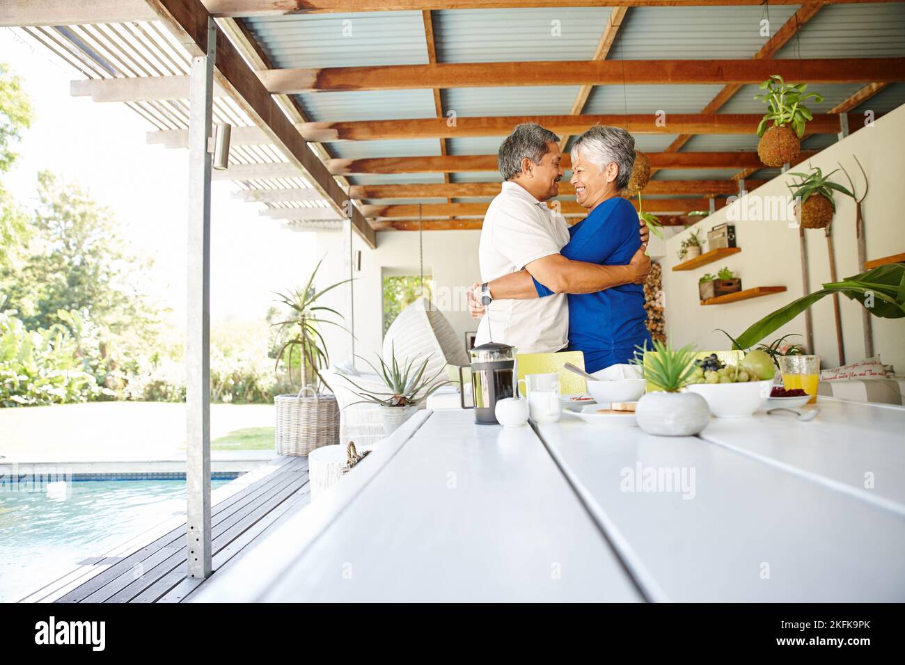 Ils n'ont jamais perdu leur chimie. Un heureux couple âgé s'est enveloppé dans une chaleureuse étreinte à la maison. Banque D'Images