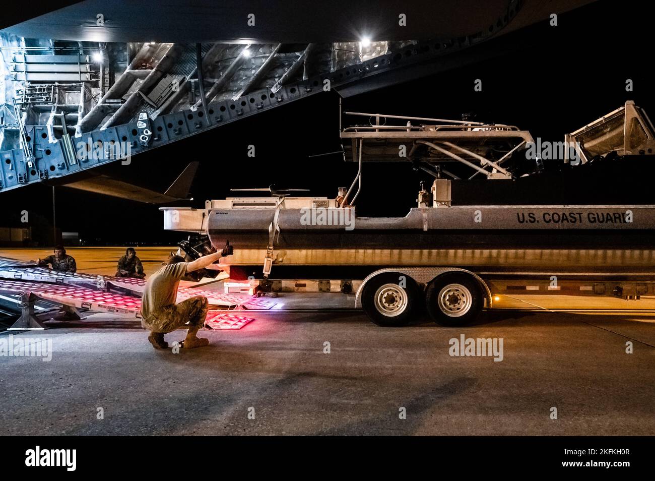 Des gardes-côtes américains de l'unité de sécurité portuaire 309 et des aviateurs américains du 375th Logistics Readiness Squadron chargent un bateau de sécurité portuaire transportable sur un C-17A Globemaster III sur la base aérienne Scott, Illinois, le 23 septembre 2022. Le PSU 309 peut être déployé dans le monde entier dans les 96 heures suivant le rappel et répondre aux missions nationales, y compris l'aide humanitaire. Banque D'Images