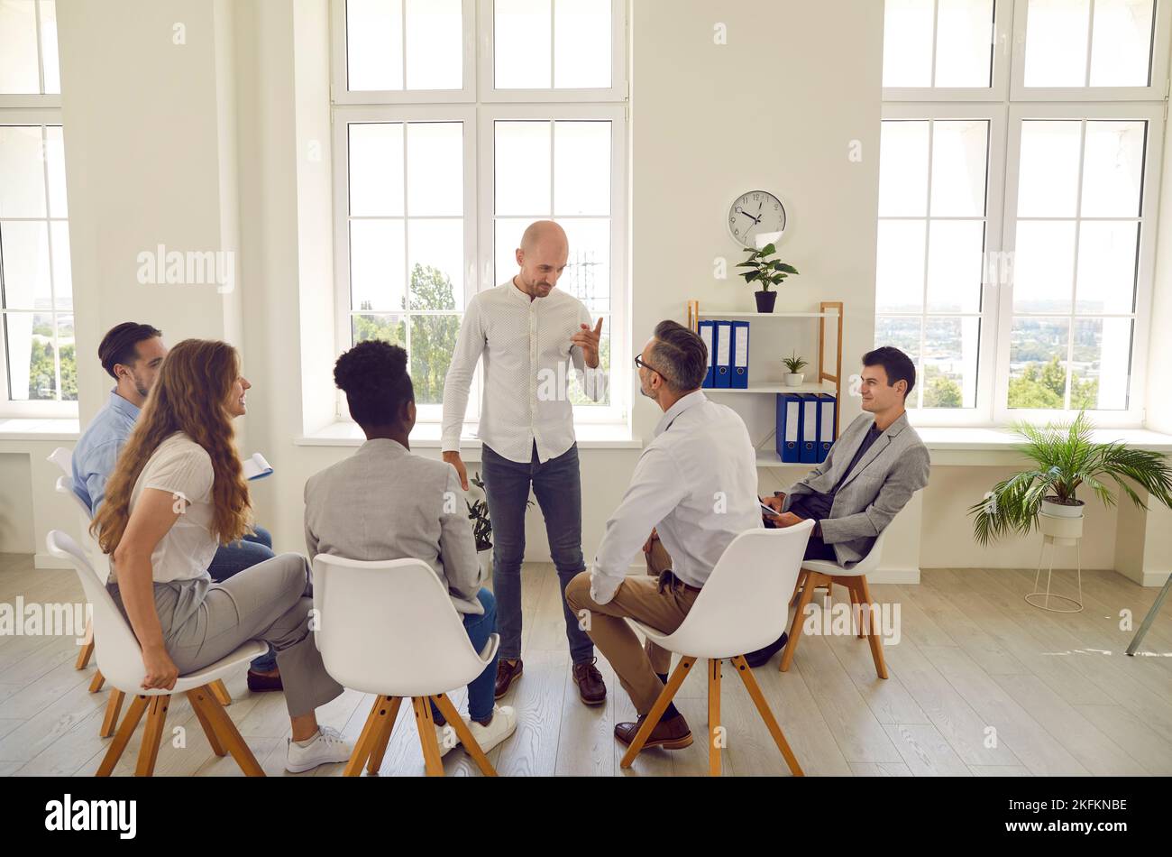 Homme entraîneur d'affaires canapé enseigne un groupe d'étudiants adultes pendant l'atelier de formation corporative. Banque D'Images