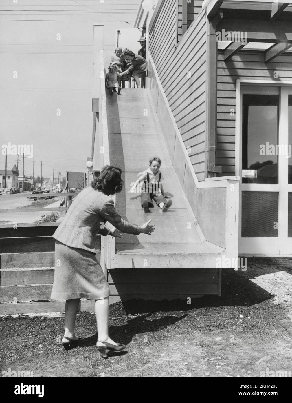 4 000 photographies de l'état d'avancement du projet de logement de l'unité 6 mars, 1943, à 11 août 1943, Richmond, CA - les enfants se palisaient, glissant vers le bas d'une diapositive.' Banque D'Images