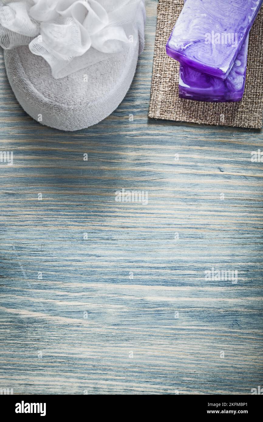 Éponge de bain blanche au savon en bois violet fait main sur planche de bois concept de soins spa. Banque D'Images