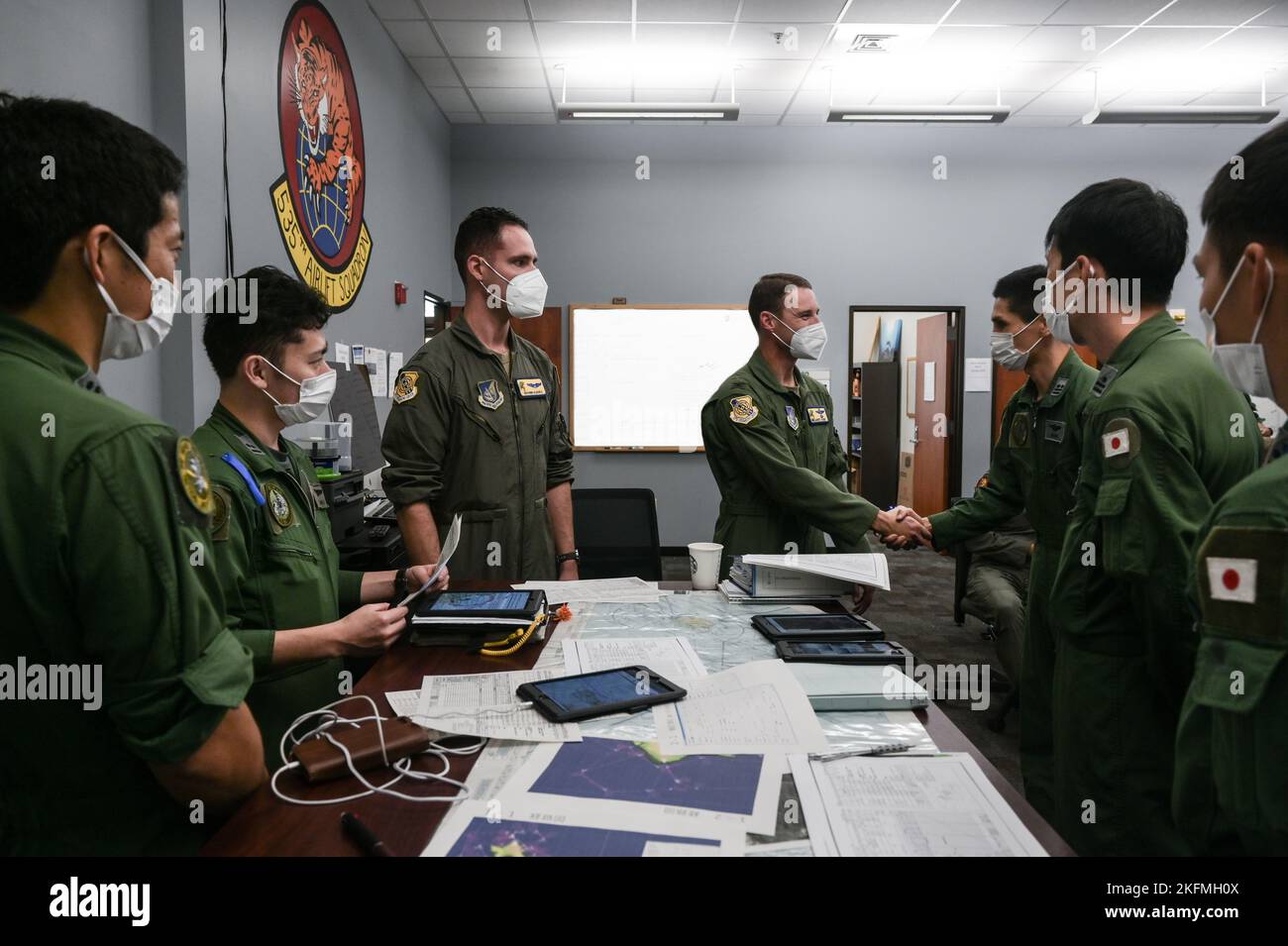 Garret Fisher, commandant du Groupe des opérations 15th de la Force aérienne américaine, et Giovanni Allevato, capitaine de la Force aérienne des États-Unis, pilote du C-17 Globemaster III du 535th Escadron de transport aérien, s'adresse à l'équipage de la Force aérienne d'autodéfense du Japon lors de l'entraînement bilatéral à la base conjointe Pearl Harbor-Hickam, à Hawaï, le 26 septembre 2022. Plus de 20 membres du JASDF sont arrivés pour participer au premier exercice bilatéral entre le C-2 de Kawasaki et le C-17. Banque D'Images