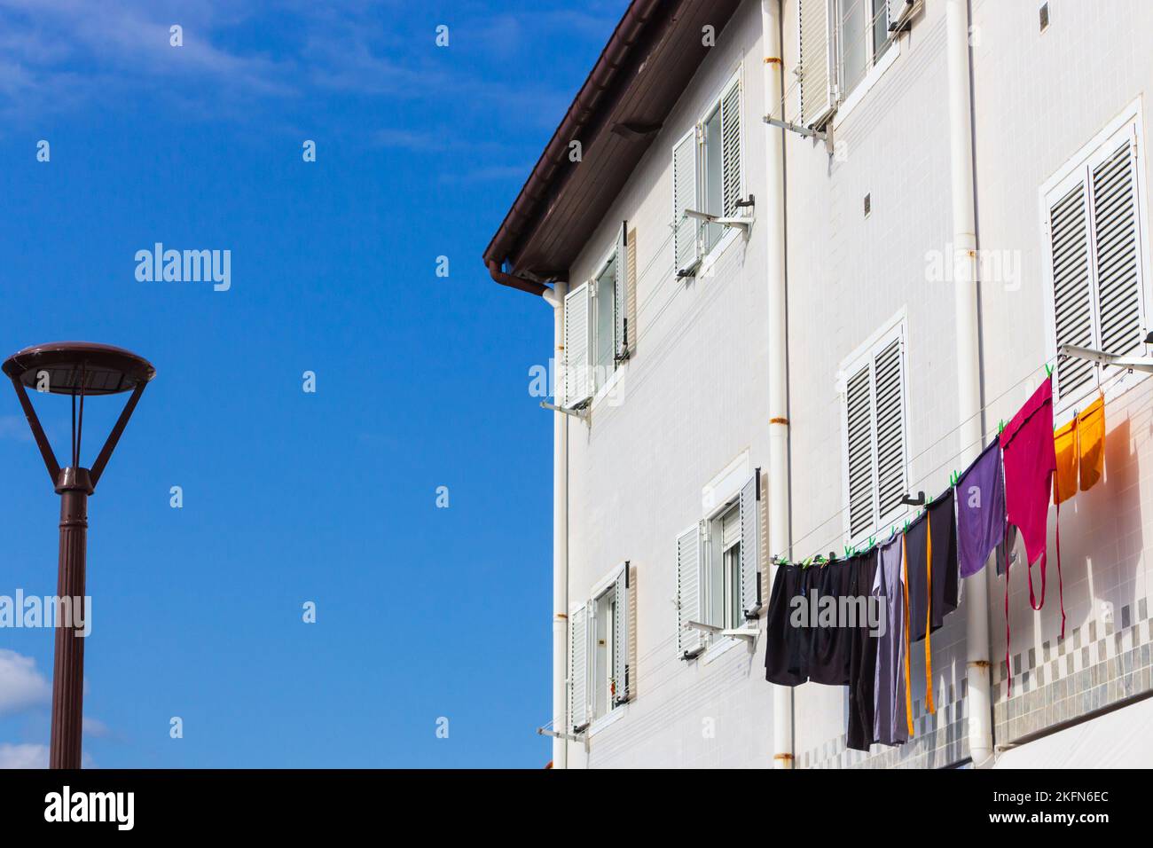 Séchage de vêtements à l'extérieur de la maison avec lanterne de rue au Portugal. Ouvrez la fenêtre et séchez le linge. Maison traditionnelle au Portugal, Lisbonne. Concept de blanchisserie Banque D'Images