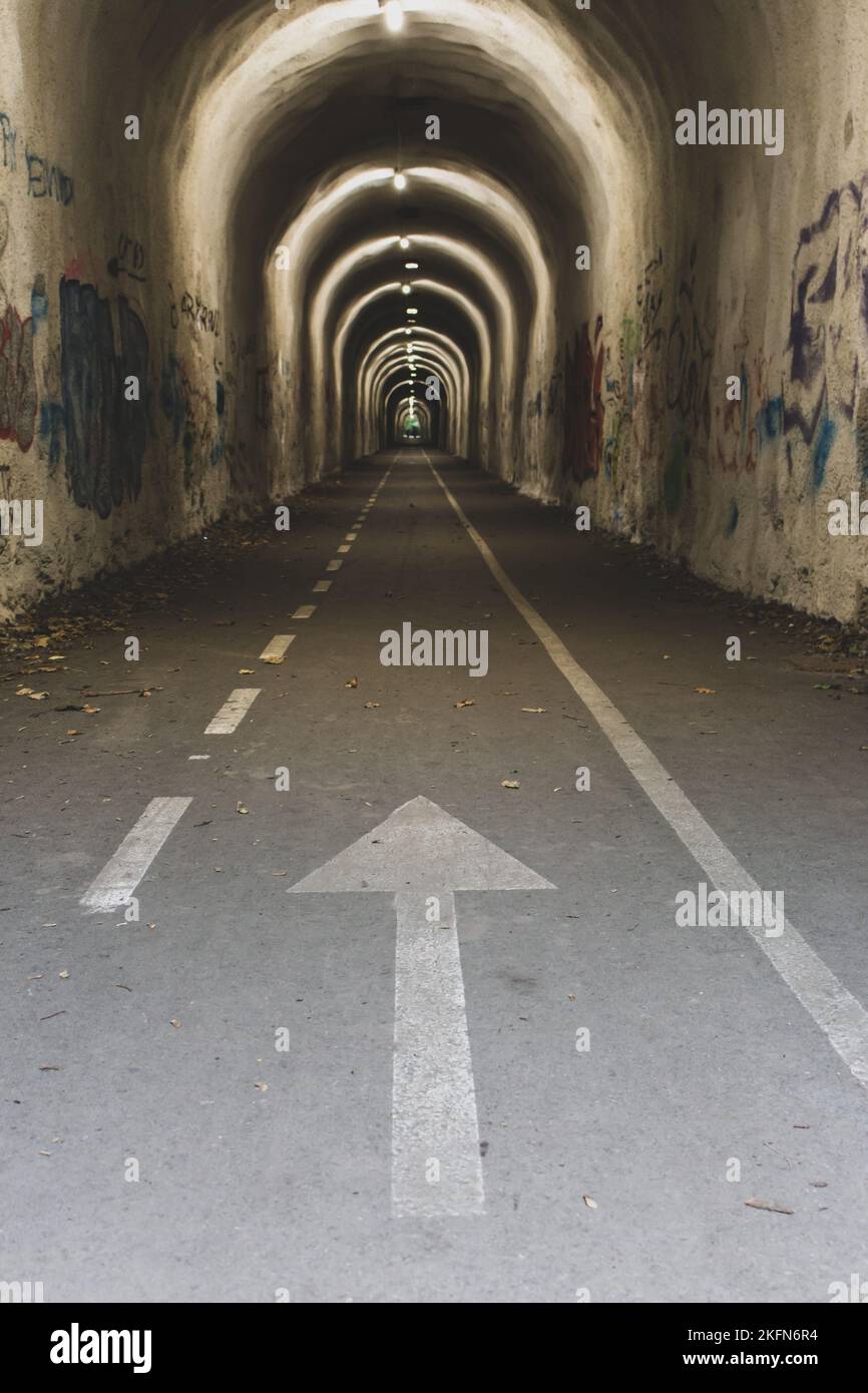 Tunnel étroit avec flèche. Tunnel vide avec panneau directionnel. Concept de destinations de voyage. Entrée au tunnel de Camino de Santiago. Banque D'Images