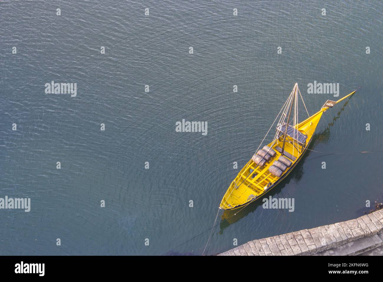 Bateau jaune sur fond noir et blanc. Bateau jaune avec vue sur les fûts de vin. Vue aérienne du bateau sur le dessus de l'eau. Bateau en bois jaune à Porto Banque D'Images