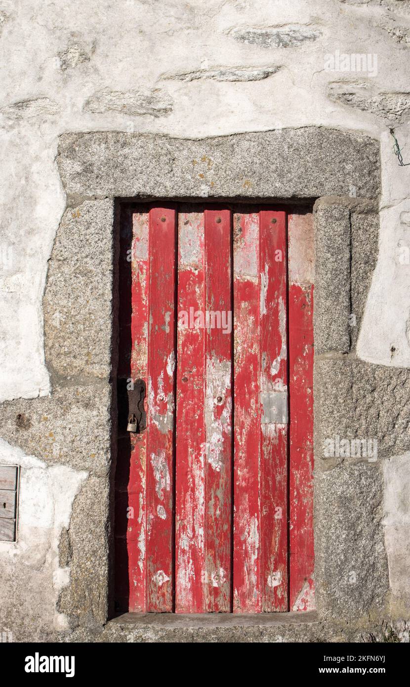 Ancienne porte rouge. Porte en bois de la maison rurale. Bâtiment en pierre avec porte en bois fermée. Concept de minimalisme. Architecture médiévale. Banque D'Images