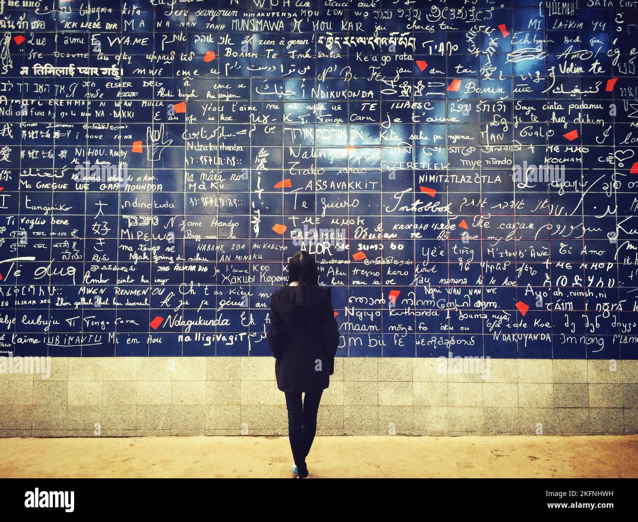 Une fille devant un mur d'amour à Paris, France. Banque D'Images