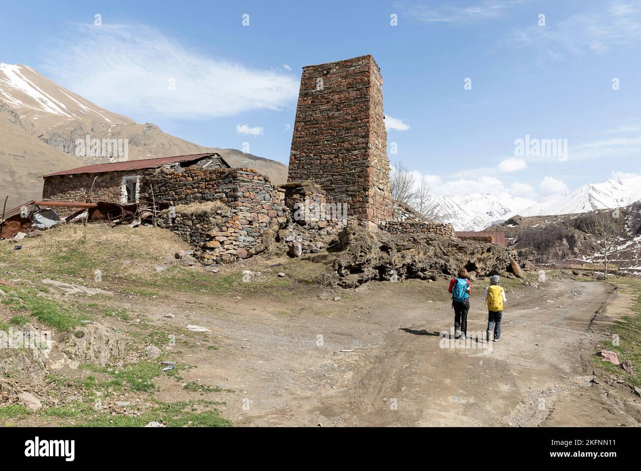 Randonneurs marchant vers la vallée de la ferme, traversant des villages en pierre abandonnés près de la frontière russe, caucase, kazbegi, géorgie Banque D'Images