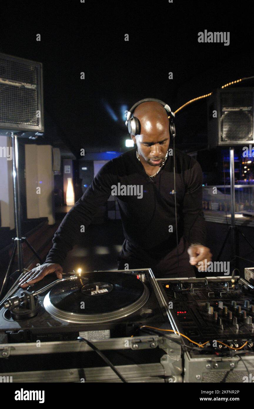 DJ SPOONY, JEUNE, DECKS, MIXEUR : DJ Spoony de BBC Radio One joue une musique de garage au 10 Club de Cardiff, pays de Galles, Royaume-Uni le 23 septembre 2004. Photographie : ROB WATKINS. INFO : DJ Spoony, DJ britannique et présentateur de radio, est un pionnier de la scène du garage britannique. Son émission de radio influente et ses DJ sets ont façonné le genre, lui valant la reconnaissance comme l'une de ses figures les plus importantes. Banque D'Images