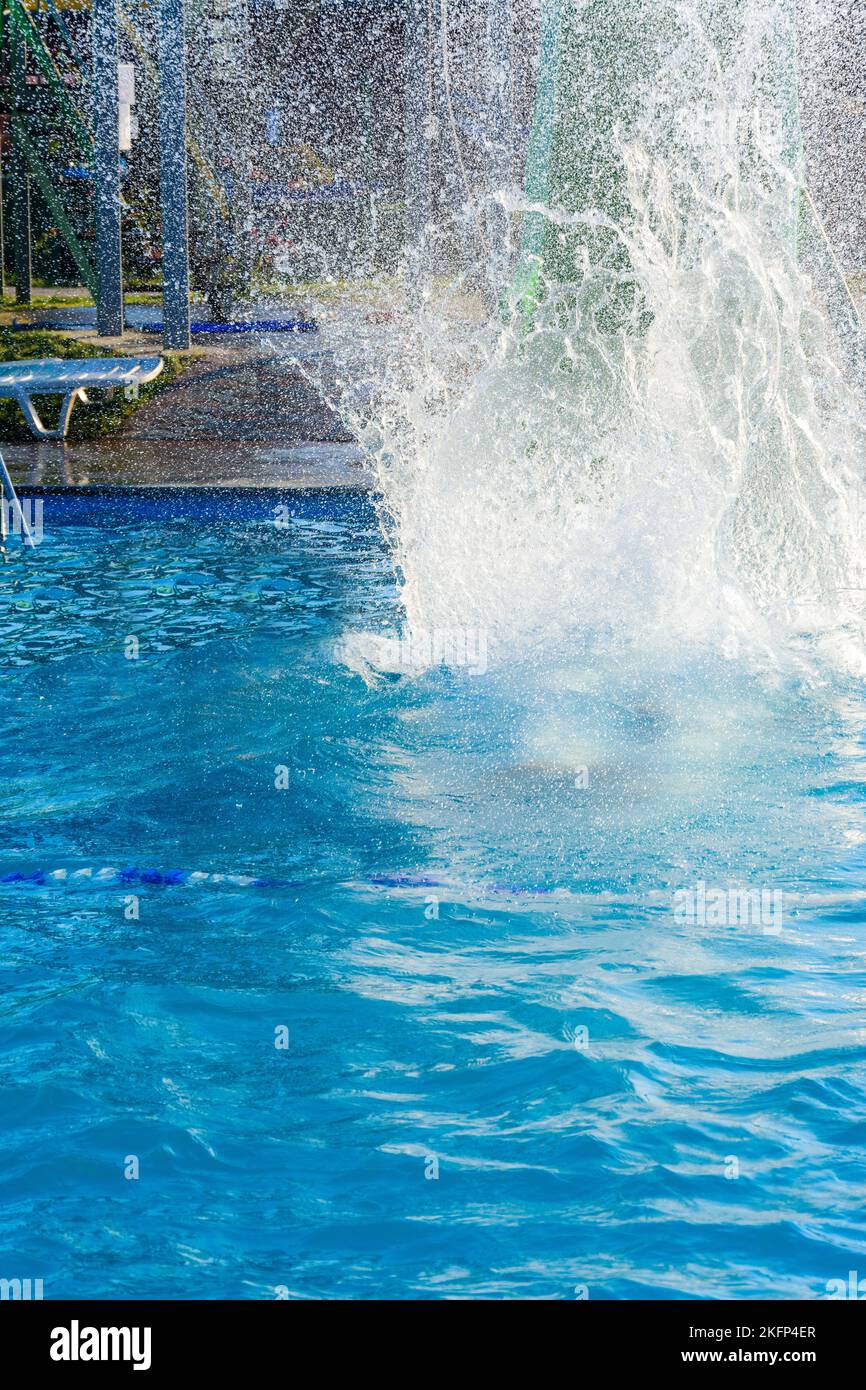 La jeune fille descend d'un toboggan aquatique dans un parc aquatique