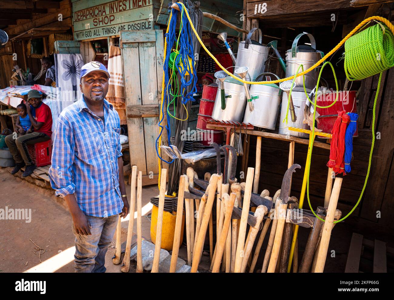 Un commerçant se tient près de son magasin hardwared sur le marché de Mzuzu, au Malawi. Banque D'Images