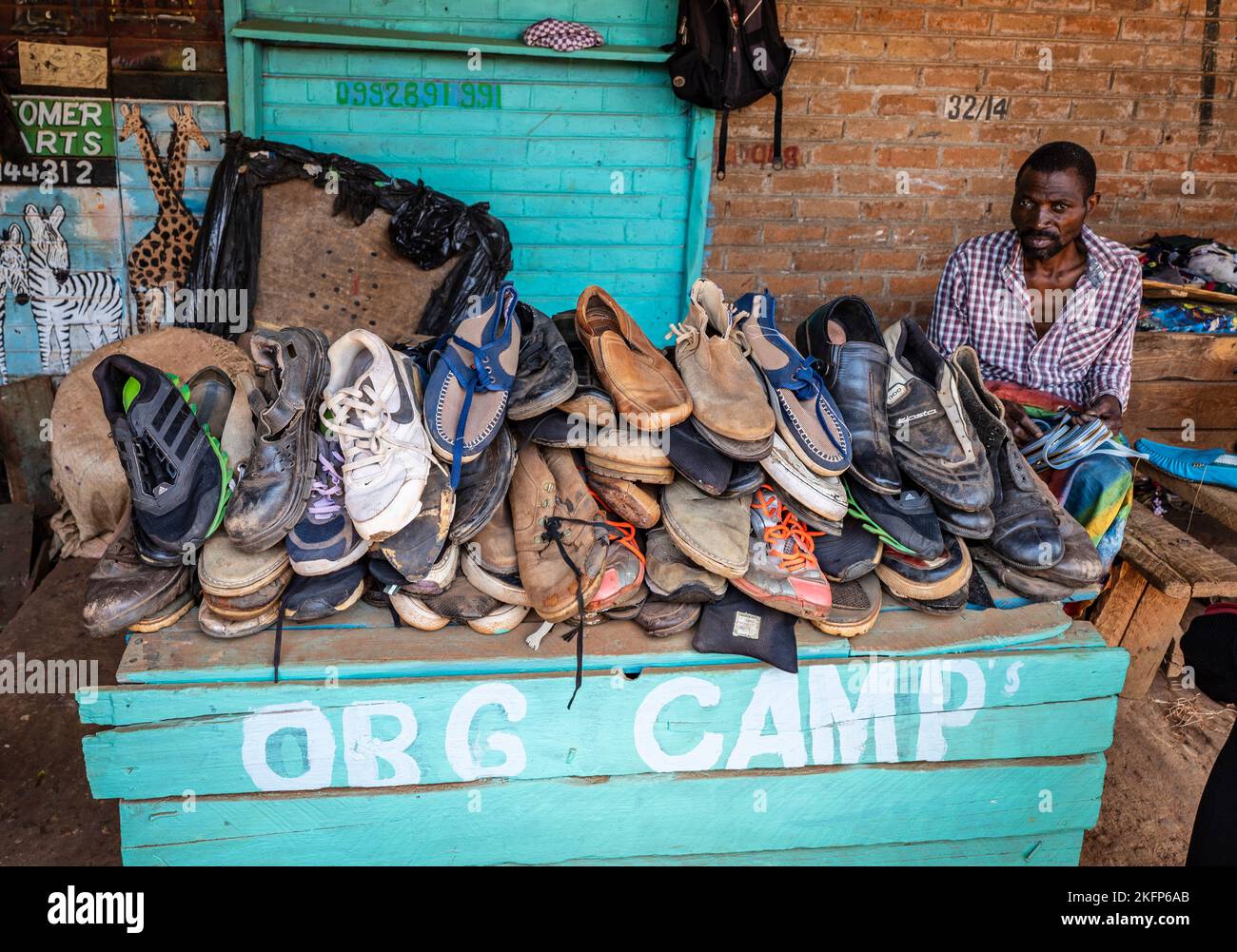 Un négociant vend des chaussures usagées sur le marché de Mzuzu, au Malawi Banque D'Images
