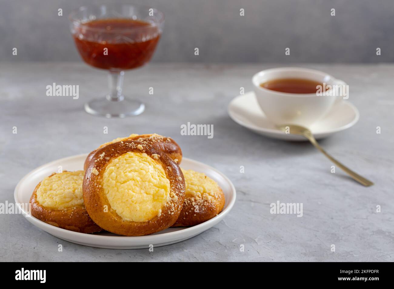cheesecake avec streusel sur fond de béton, thé avec tartes et confiture Banque D'Images