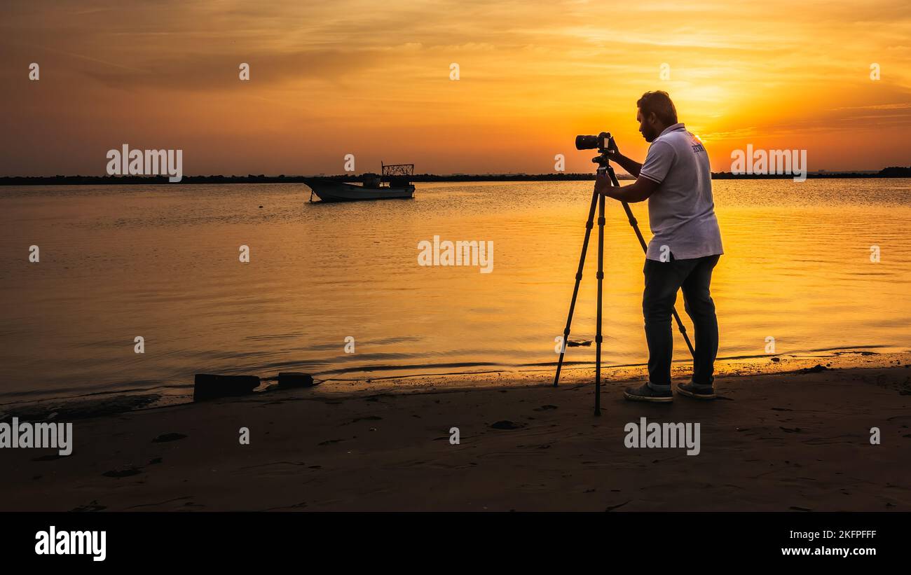 Un photographe debout en face de la mer pour prendre des photos. Dammam corniche, Arabie Saoudite. Banque D'Images