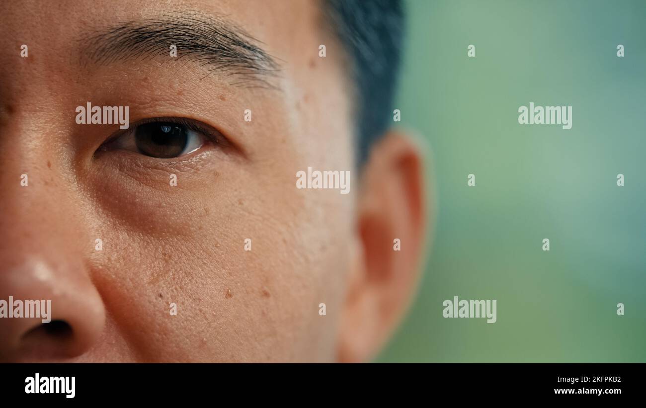 Gros plan asiatique visage de sexe masculin yeux partie du corps en détail coréen japonais adulte en bonne santé homme 40s avec la vue sombre homme d'affaires client d'ophtalmologie après Banque D'Images