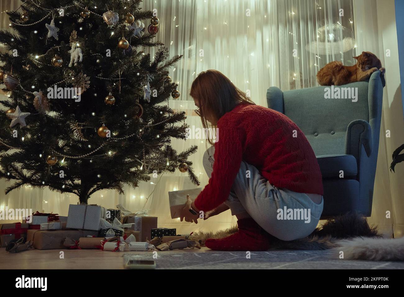 Femme mettant des cadeaux sous l'arbre de Noël la veille de Noël ou la veille du nouvel an la nuit Banque D'Images
