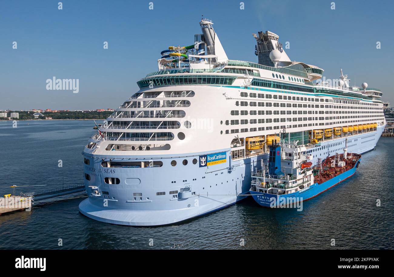 Estonie, Tallinn - 21 juillet 2022 : le pétrolier Blue Ristna fait le plein de Voyager blanc des mers, navire de croisière Royal caribbean amarré dans le port sous le ciel bleu Banque D'Images