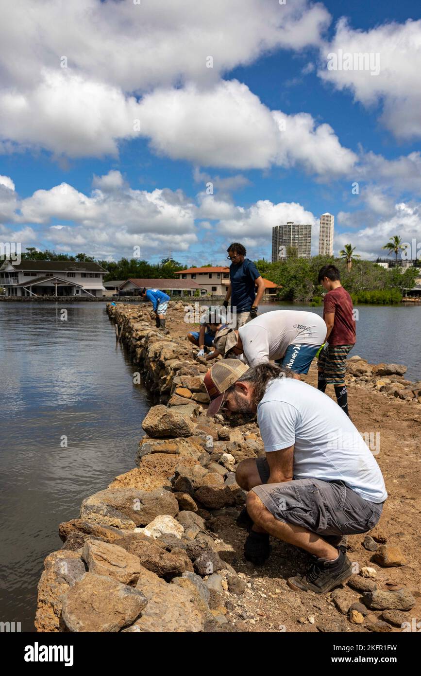 221001-N-OT701-1054 BASE CONJOINTE PEARL HARBOR-HICKAM (OCT 1, 2022) les membres de la communauté locale répare le mur de l'étang de poissons Loko Pa'aiau. Les marins se sont associés avec des membres de la communauté locale pour aider à restaurer l'étang à poissons Loko Pa'aiau en enlevant les espèces végétales envahissantes et en réparant le mur de l'étang à poissons. Banque D'Images