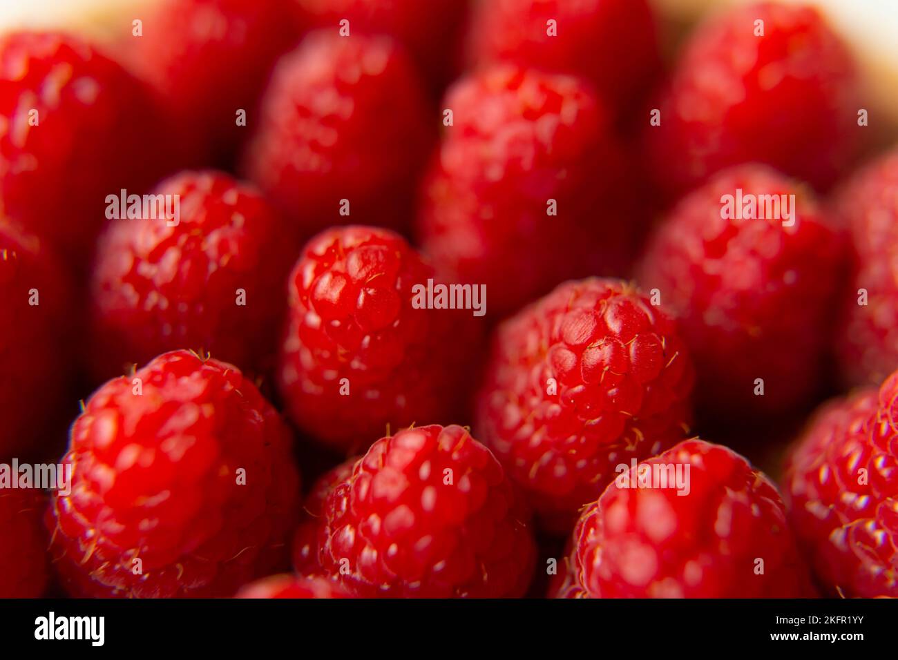 Gros plan sur un magnifique stand de framboises, fruits d'été. Les fruits sont bons pour la santé. Une alimentation adéquate, des aliments crus. Banque D'Images