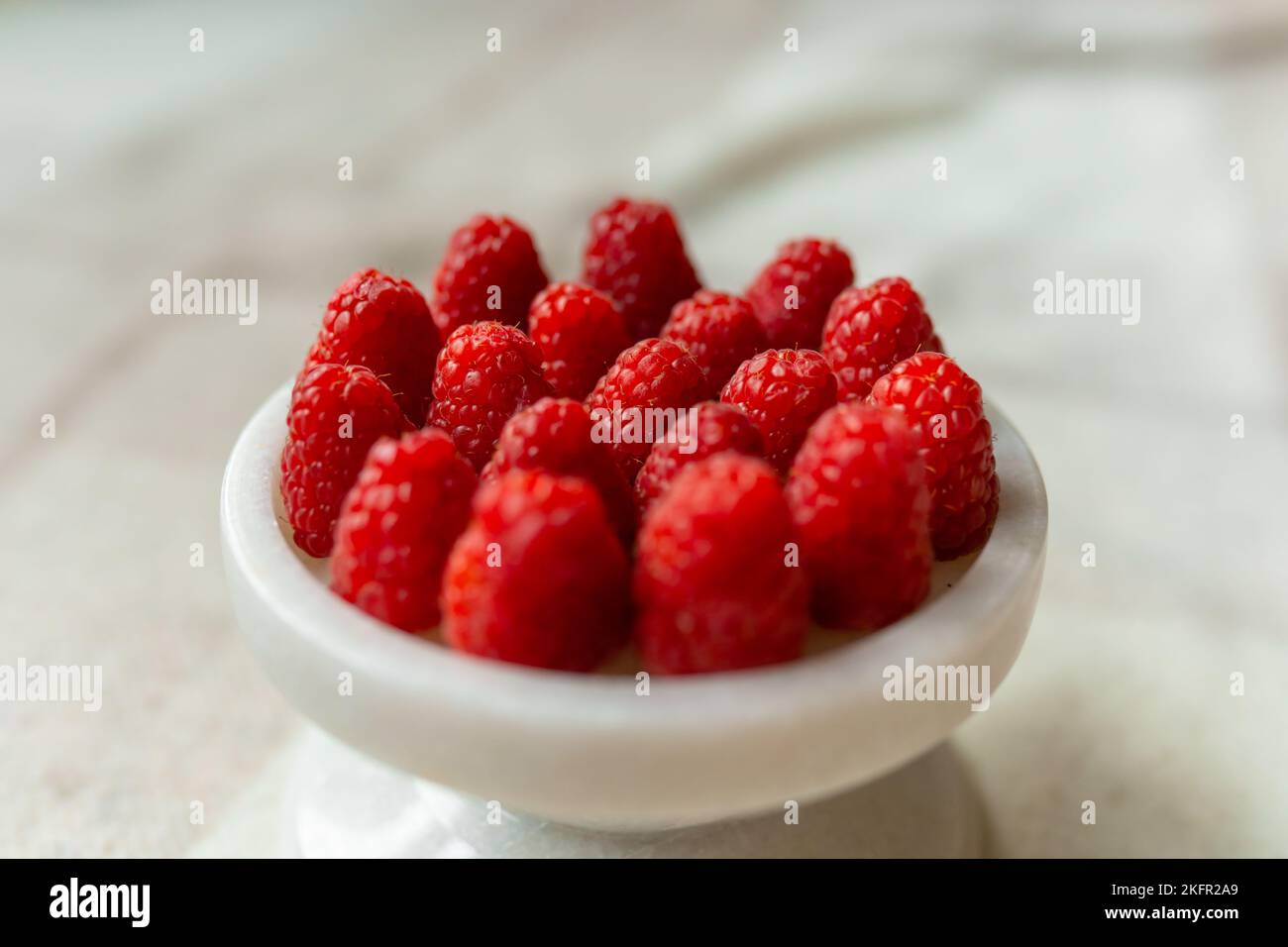 Gros plan sur un magnifique stand de framboises, fruits d'été. Les fruits sont bons pour la santé. Une alimentation adéquate, des aliments crus. Banque D'Images