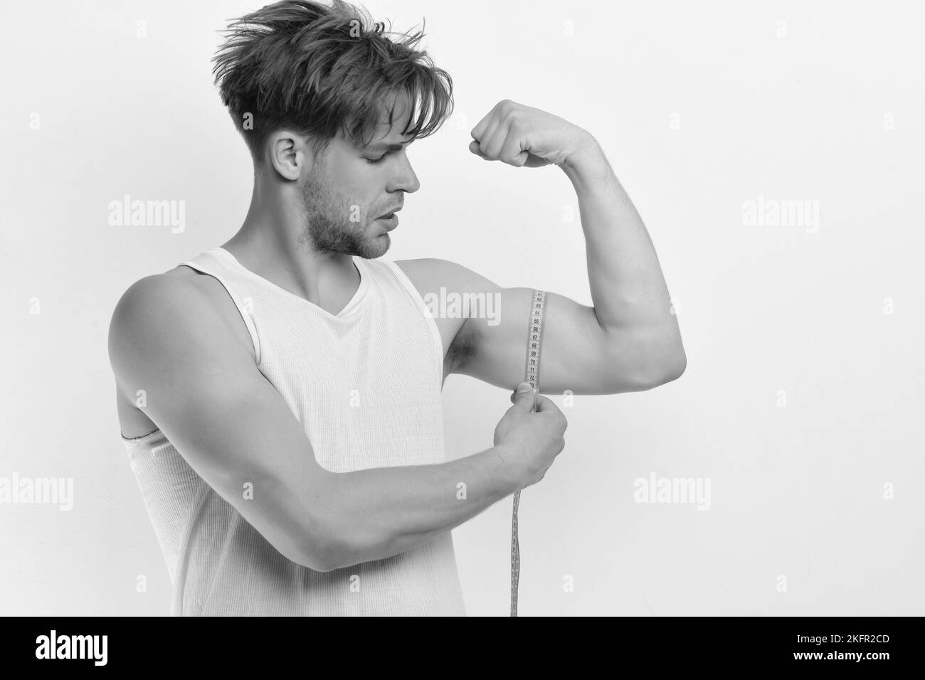 Athlète avec des cheveux désordonnés montrant biceps et triceps Banque D'Images