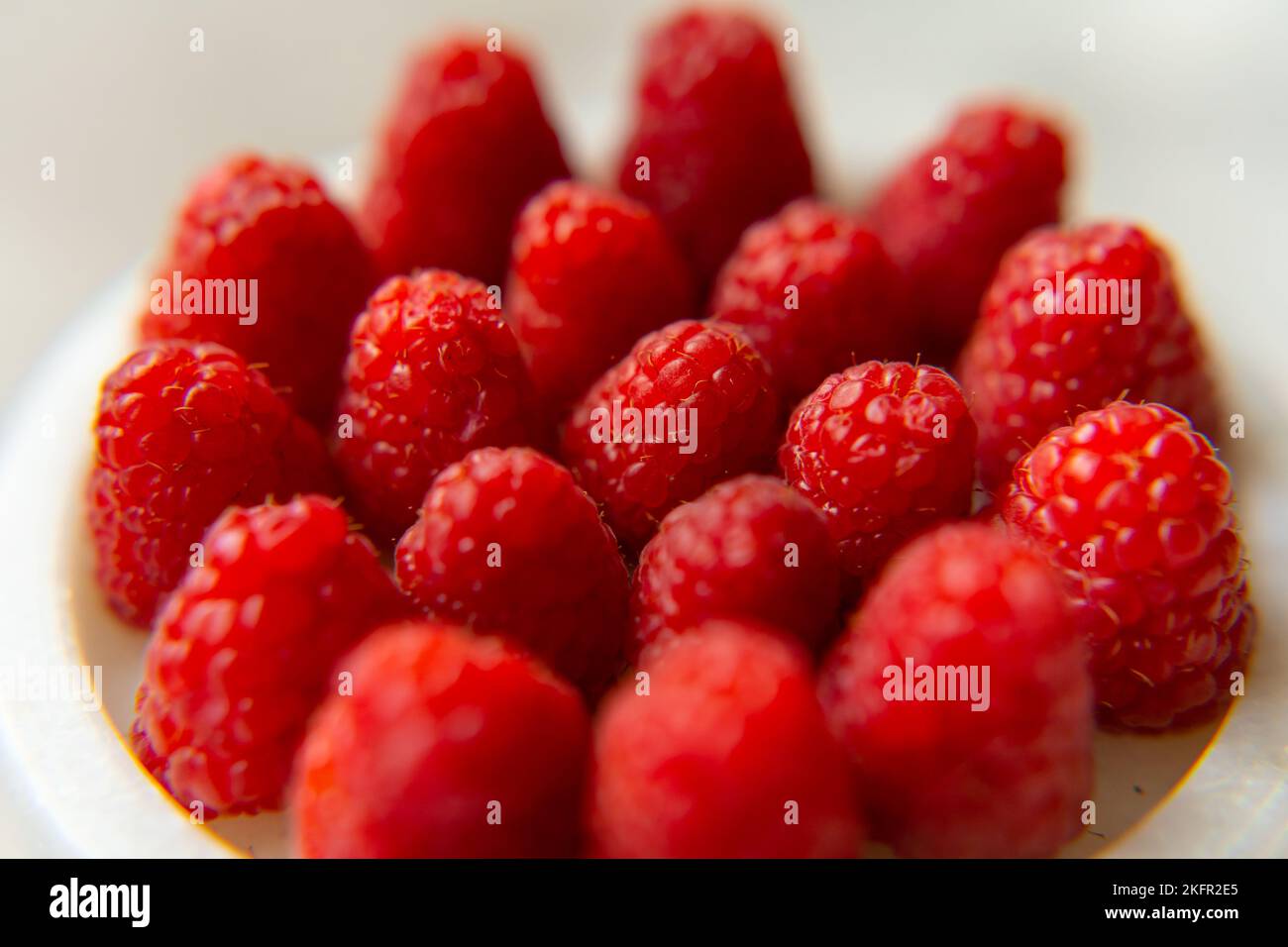 Gros plan sur un magnifique stand de framboises, fruits d'été. Les fruits sont bons pour la santé. Une alimentation adéquate, des aliments crus. Banque D'Images