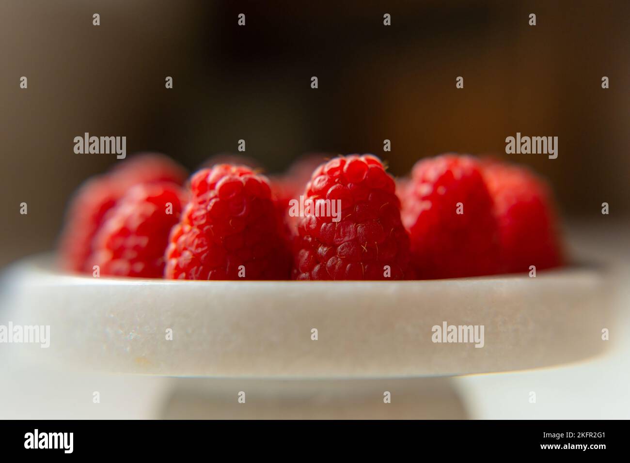 Gros plan sur un magnifique stand de framboises, fruits d'été. Les fruits sont bons pour la santé. Une alimentation adéquate, des aliments crus. Banque D'Images