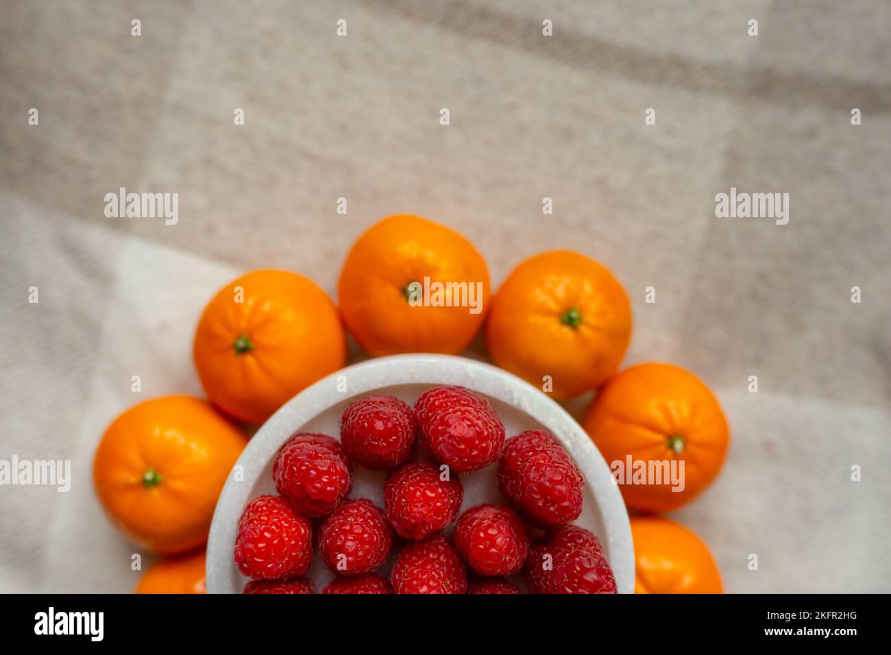 Gros plan sur les framboises et les mandarines. Les fruits sont bons pour la santé. Une alimentation adéquate, des aliments crus. Aliments biologiques. Banque D'Images