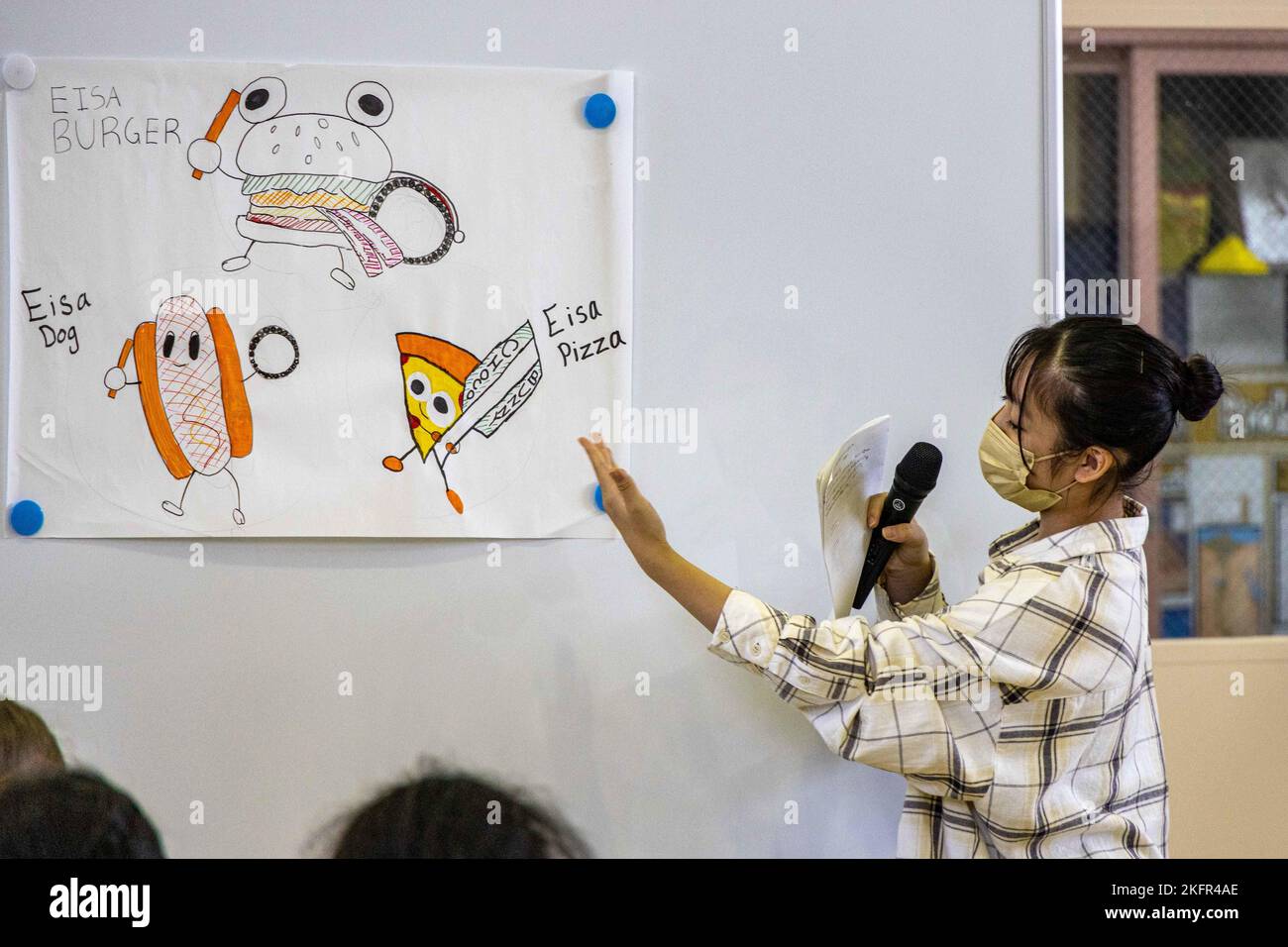 Un étudiant présente la mascotte de son groupe lors du programme d