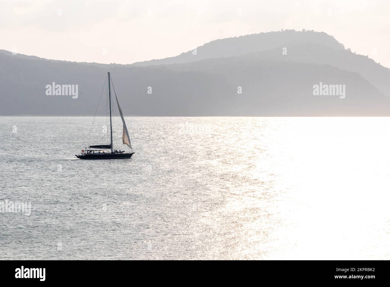 Yacht naviguant vers le soleil, Cap Panwa, Phuket, Thaïlande Banque D'Images