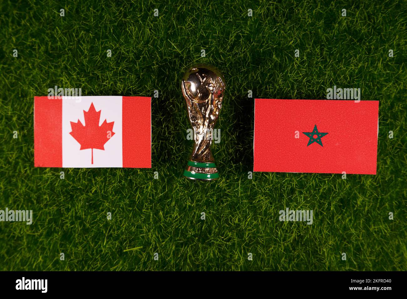 20 novembre 2022, Doha, Qatar. Drapeaux du Maroc et du Canada et trophée de la coupe du monde de la FIFA sur la pelouse verte du stade. Banque D'Images