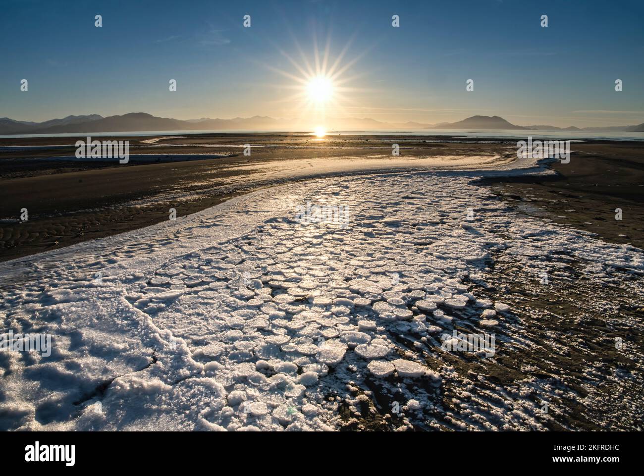 Des cercles de glace se sont coincés sur la plage à marée basse avec un coucher de soleil sur une journée d'hiver ensoleillée dans le sud-est de l'Alaska. Banque D'Images