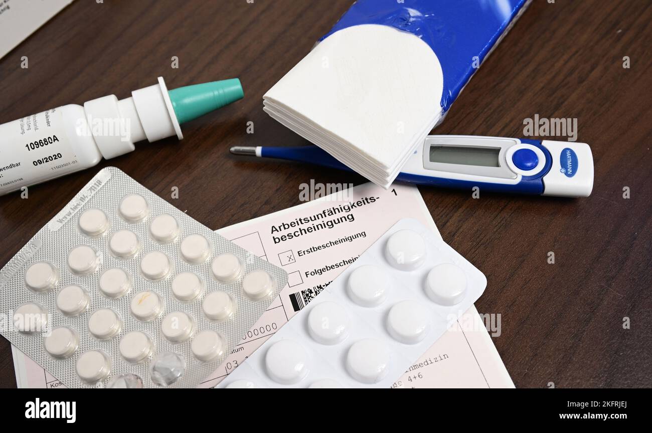 Stuttgart, Allemagne. 18th novembre 2022. Un thermomètre de fièvre, un médicament et un certificat d'incapacité de travail du médecin (note de maladie) sont posés sur une table de chevet (scène posée). Avec la saison froide, les infections de la grippe sont à nouveau en hausse. Credit: Bernd Weißbrod/dpa/Alay Live News Banque D'Images