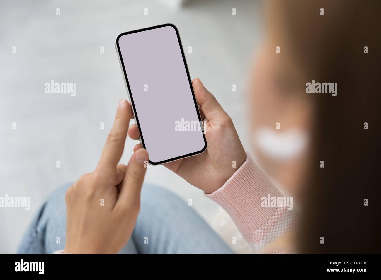 Femme tenant un smartphone avec un écran maquette blanc, gros plan Banque D'Images