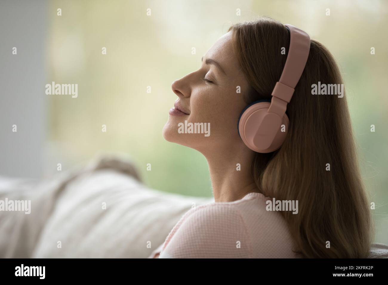 Vue latérale visage sereine femme porter un casque écouter de la musique Banque D'Images